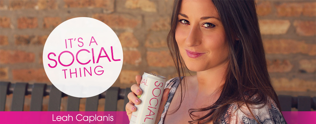 Brunette fair skin woman holding a white can of SOCIAL wine in front of a brick wall with the caption It's a social thing