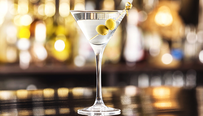 classic martini cocktail on a glossy black bar top