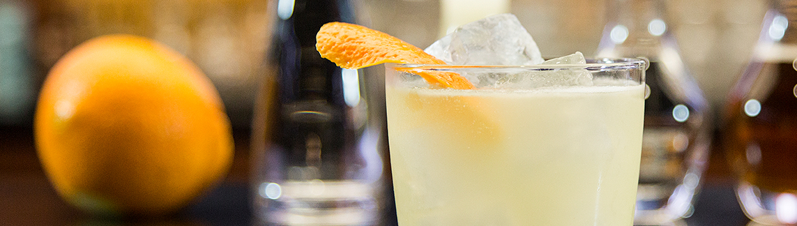 Margarita with fruit and bar tools in the background