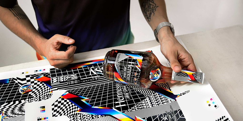 Artist Felipe Pantone holds his V.S. Limited Edition Hennessy bottle